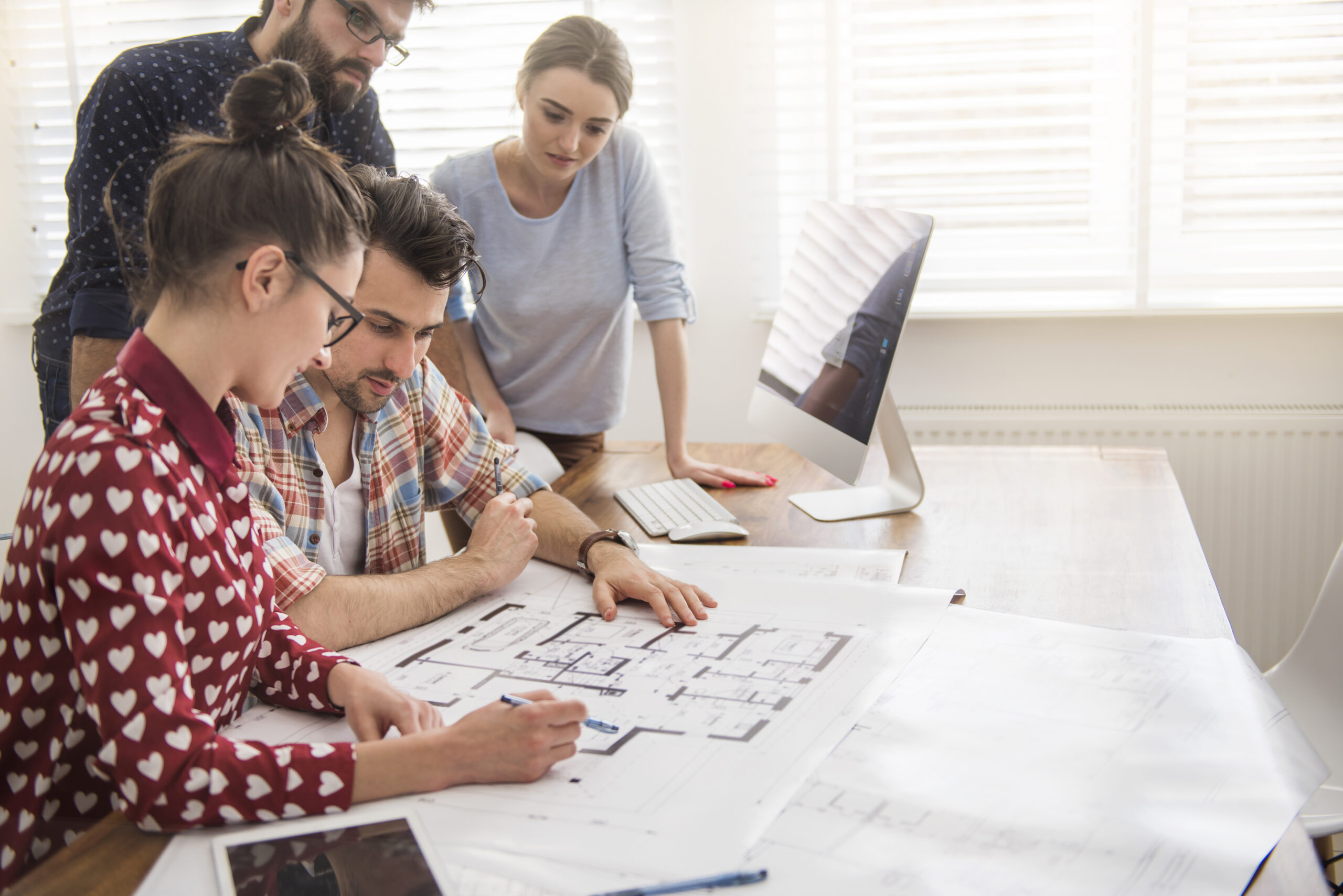 Teamarbeit mit Architekturplänen im Büro