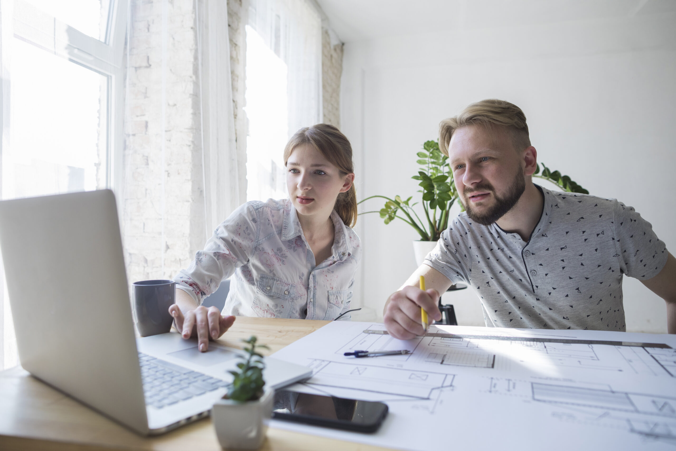 Zwei Mitarbeiter arbeiten gemeinsam am Laptop